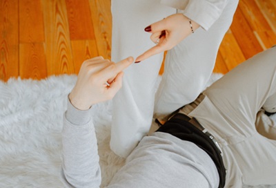 Man lying on floor trying to touch woman standing