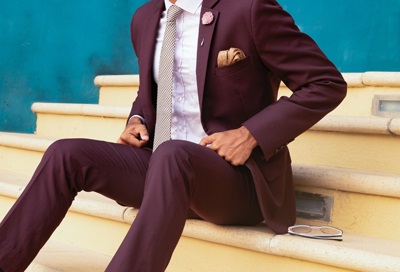 Man in a suit sitting on steps.