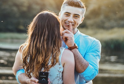 A photo of a man secretly about to propose to the woman he’s hugging